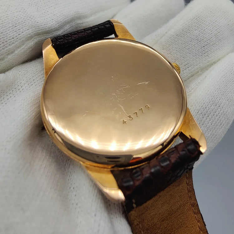 Montre Zenith Automatic vintage de 1955 avec cadran champagne, mouvement automatique, photographiée sur fond.